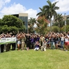 The Nova Southeastern University community comes together to celebrate Arbor Day with a tree planting ceremony and environmental stewardship and education fair. Participants gather around the newly planted tree with a "Fins Up" from the NSU Sharks.