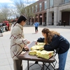 A student chooses a 2023 Earthstock T-shirt.